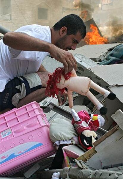 Un hombre trata de rescatar algunos juguetes de entre los escombros de un edificio destruido en Beirut.