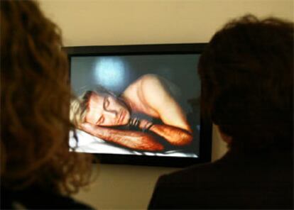 Varios visitantes contemplan el vídeo del David Beckham durmiente.