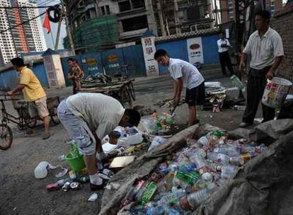 Ciudadanos chinos recogen basura en una calle de Pekín.