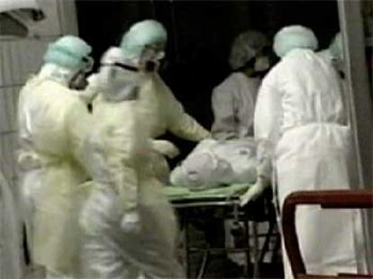Varios enfermeros trasladan al hospital al médico afectado por la neumonía asiática.
