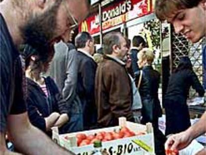 Miembros de grupos antiglobalización preparan pan con tomate ante un McDonald's en Gràcia.