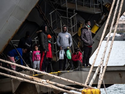 Un grupo de migrantes se asoman al exterior desde un buque griego atracado en el puerto de Mitilene, en la isla de Lesbos. ÁLVARO GARCÍA