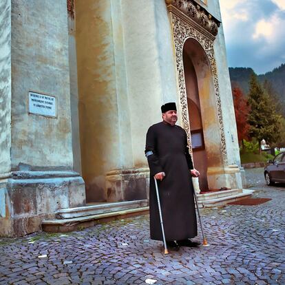 Un sacerdote ortodoxo, religión mayoritaria en el país, junto a su iglesia en la localidad de Brasov.