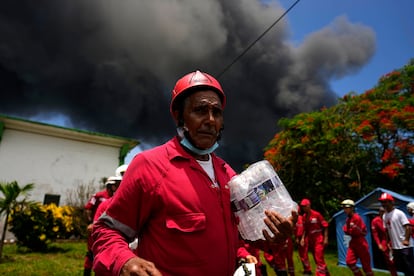 Miembros de la Cruz Roja Cubana participan en las labores para apagar el incendio.