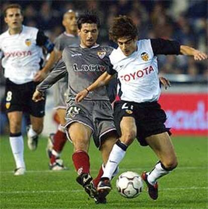 El valencianista Aimar, (dcha.) intenta controlar el balón ante Martí.