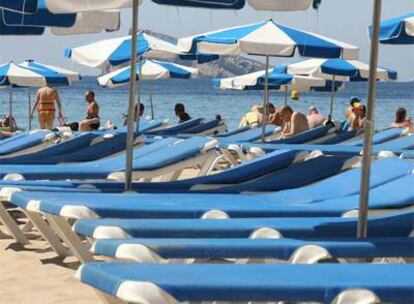 Hasta en la popular playa de Benidorm (Alicante) hay tumbonas vacías, claro síntoma del descenso del turismo de sol y playa.