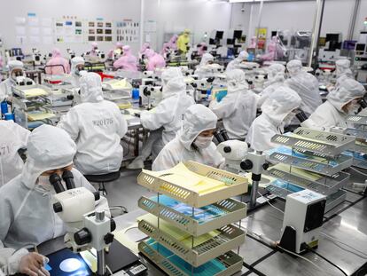 Empleados trabajan en una línea de producción de chips de Huanan.