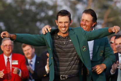 Charl Schwartzel luce la chaqueta verde de campeón junto a Phil Mickelson, su predecesor.