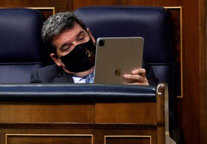 MADRID, 14/04/2021.- El ministro de Inclusión, Seguridad Social y Migraciones, José Luis Escrivá, revisa su tableta durante la sesión de este miércoles en el Congreso de los Diputados en la que el presidente del Gobierno, Pedro Sánchez, compareció para dar cuenta de la gestión del actual estado de alarma que expira el 9 de mayo y detallar las inversiones y reformas del plan de recuperación que España remitirá a la Comisión Europea este mes de abril. EFE/Chema Moya