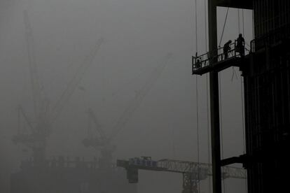 Trabajadores chinos trabajan en las obras de un edificio en construcción en Pekín (China), el día 1 de diciembre. Pekín sigue en niveles máximos de contaminación por tercer día consecutivo.