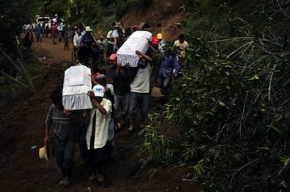 Varios guatemaltecos cargan hoy, lunes 31 de mayo de 2010, dos de los 11 cuerpos de miembros de su comunidad que perecieron víctimas de un alud de tierra en la aldea Santa Apolonia, departamento de Chimaltenango, a 110 kilómetros al occidente de Ciudad de Guatemala.