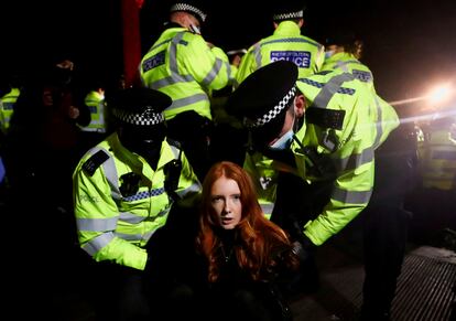 Agentes de Scotland Yard detienen a una mujer la noche del sábado en la vigilia de Clapham, en Londres. 