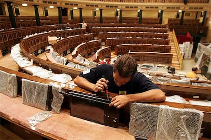 Un técnico trabaja en la instalación de monitores en los escaños del Congreso de los Diputados.