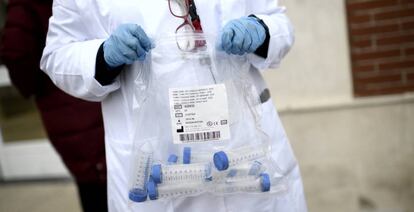 Un sanitario con tubos de ensayo durante la realización de tests de RT-PCR,