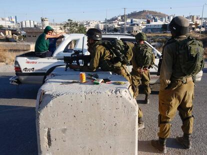 Soldados israelíes registran un coche en un control entre Hebrón y la aldea de Yatta.