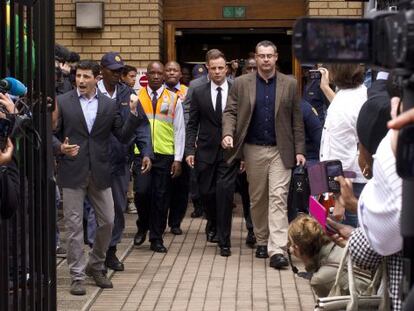 Pistorius (en el centro, con corbata), al salir hoy del tribunal.
