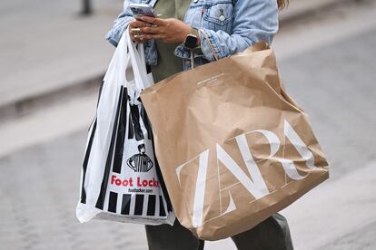 Una mujer pasea por la calle tras hacer unas compras.