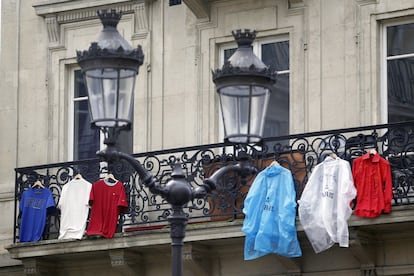 Camisetas y chubasqueros con la bandera tricolor francesa en un balcón de un apartamento de Paris.