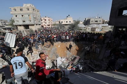 Palestinos observan, mientras otros buscan entre los escombros de una casa destrozada a causa de un ataque israelí, este jueves en Rafah.