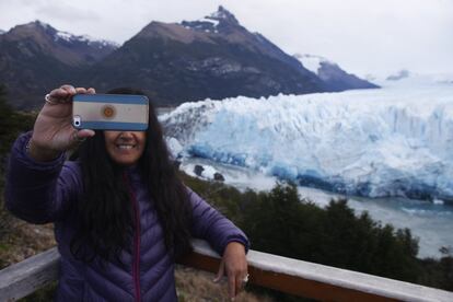 El Perito Moreno, con una extensión de unos 200 kilómetros cuadrados, está situado sobre la cordillera de Los Andes, límite natural entre Argentina y Chile, y es uno de los pocos del mundo que se mantiene estable, sin retroceder como consecuencia del calentamiento global. En la imagen, una turista toma un selfi con el glaciar Perito Moreno de fondo.