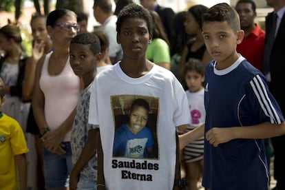 O Carnaval deste ano no Rio será lembrado pela onda de violência que antecedeu a festa mais importante da cidade. Enquanto milhares de pessoas curtiam o pré-carnaval, as operações policiais se sucediam nas comunidades mais pobres. Numa ação no complexo de favelas da Maré, na terça, o menino de 13 anos Jeremias Moraes da Silva foi morto enquanto jogava futebol. Na foto, um garoto veste uma camisa com a imagem do jovem assassinado durante o enterro.