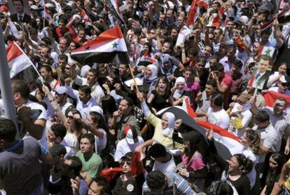 Seguidores del presidente sirio Bachar el Asad agitando banderas sirias en Damasco, Siria.