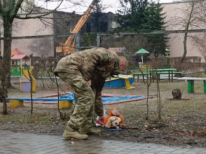 Un soldado, vecino de la zona, deposita unos peluches como ofrenda a los niños del barrio fallecidos.