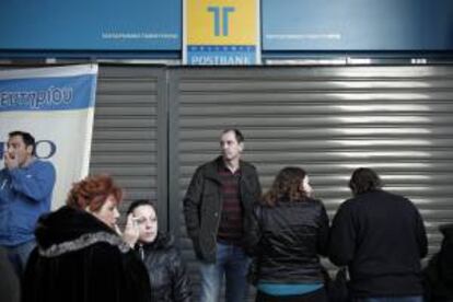 Trabajadores de Hellenic Postabank protestan por la privatización del banco a las afueras de la sede de Atenas, Grecia hoy.