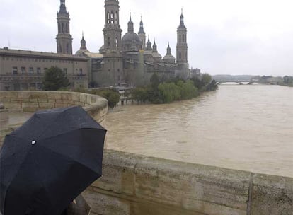 Vista del cauce del río Ebro a su paso por el puente de Piedra en Zaragoza, cuya crecida ha alcanzado los 2.142 metros cúbicos por segundo en la madrugada del Jueves Santo. Está previsto que la riada no comience a decrecer en la capital aragonesa hasta el viernes por la mañana.