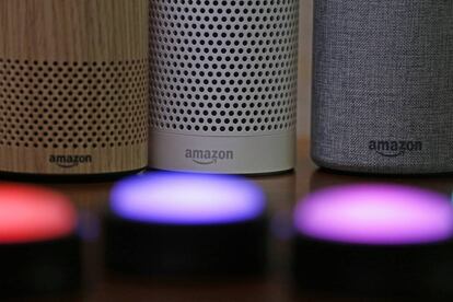 FILE - In this Sept. 27, 2017, file photo, Amazon Echo and Echo Plus devices, behind, sit near illuminated Echo Button devices during an event announcing several new Amazon products by the company in Seattle. Amazon is expanding its home-security business by buying Ring, the maker of Wi-Fi-connected doorbells. The deal comes months after the online retailer started selling its own Wi-Fi-connected indoor security cameras, which work with its voice-assistant Alexa. (AP Photo/Elaine Thompson, File)