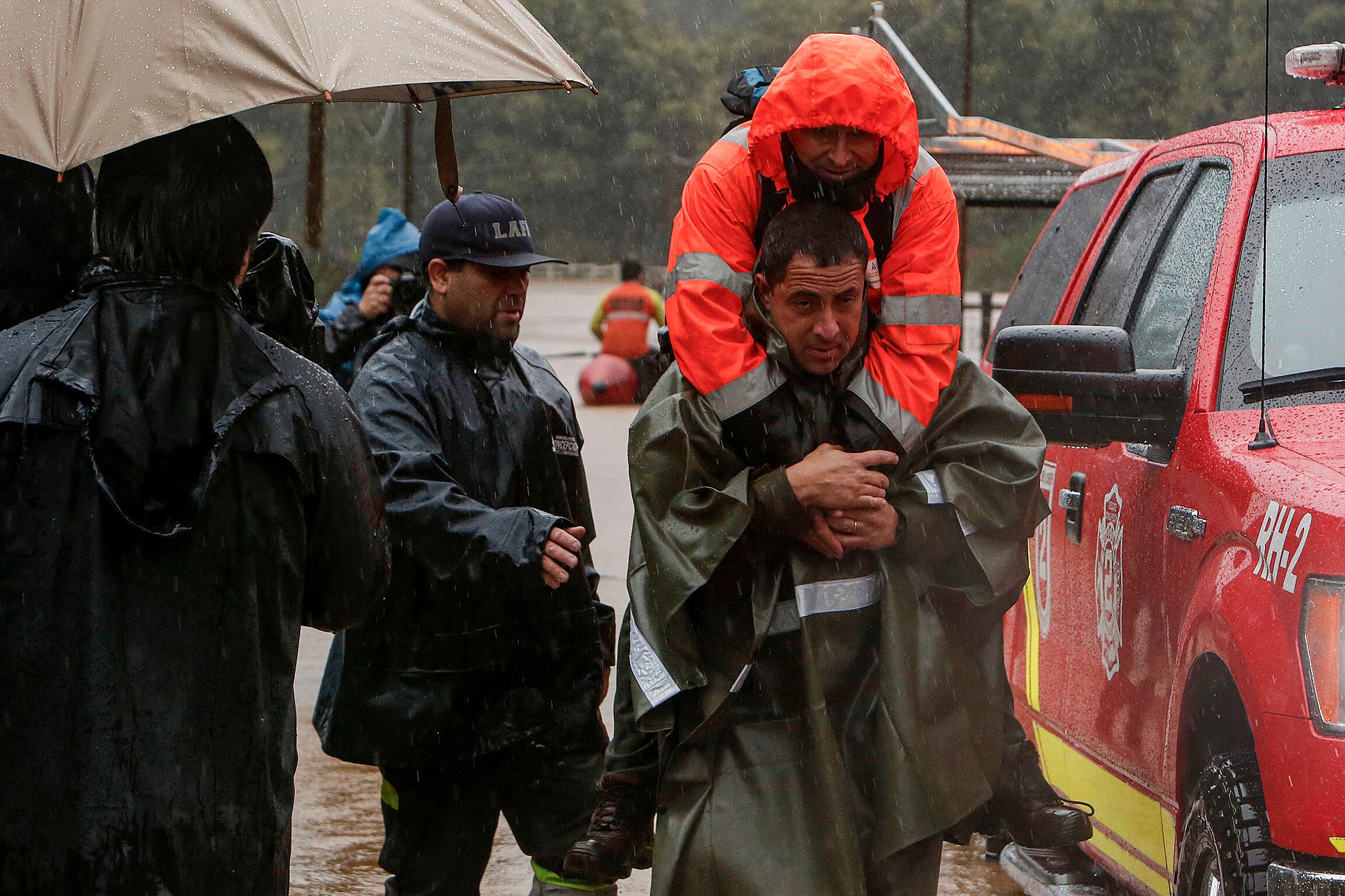 Un Carabinero evacúa a un hombre que se mantenía aisladotras el desborde del río Andalién este miécoles en la comuna de Concepción región del Biobío (Chile). 