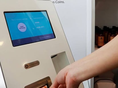 Un cliente introduce un billete en una máquina Bitcóin para comprar criptomoneda.