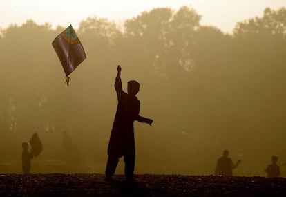 Niños afganos juegan con cometas al atardecer, en las afueras de Herat (Afganistán).