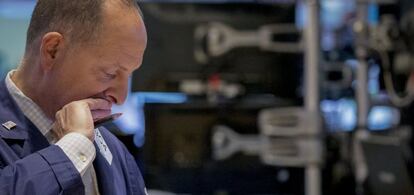 No está mirando la comanda, sino atendiendo a su portfolio del día: operativba en el NYSE en Wall Street, en Nueva York.