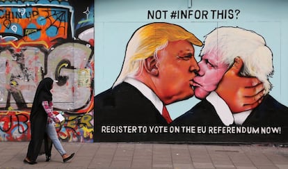 Uma transeunte ao lado de um mural que mostra o presidente dos Estados Unidos, Donald Trump, beijando o ex-prefeito de Londres Boris Johnson ao lado de um prédio em Bristol (Reino Unido), em 24 de maio de 2016. O mural foi encomendado pela We Are Europe, um grupo de campanha que apoiou a permanência da Grã-Bretanha na União Europeia.