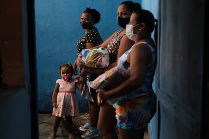 Vecinas de una favela de Río de Janeiro, tras recibir donaciones en una escuela, el pasado abril.