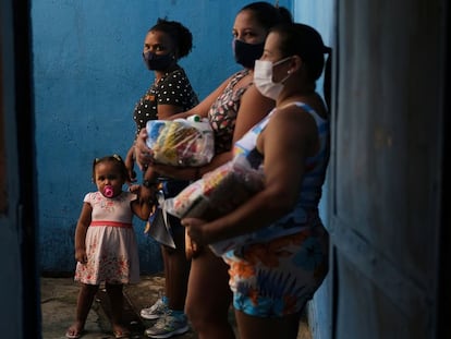 Vecinas de una favela de Río de Janeiro, tras recibir donaciones en una escuela, el pasado abril.