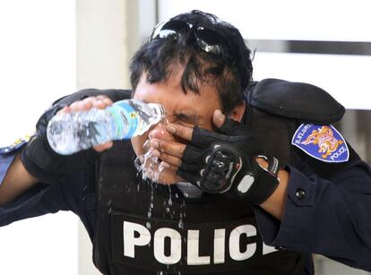 Un policía antidisturbios se lava la cara tras haber sido rociado con gases lacrimógenos.