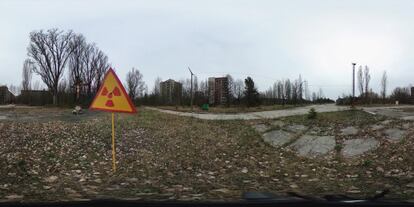 Una señal que alerta de contaminación por radiación cerca de unos edificios de apartamentos en Pripyat (Ucrania), el 9 de abril de 2016.