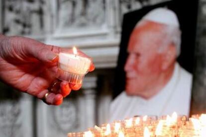 Un hombre enciende una vela ante una imagen del papa Juan Pablo II en la catedral de Saint Gödele de Bruselas.