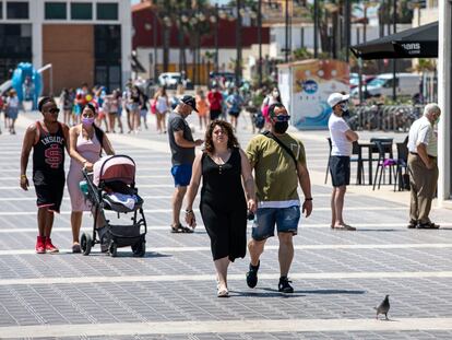 Personas sin mascarilla y con ella en el paseo marítimo de la playa Malvarrosa de Valencia durante el primer día en el que no era obligado su uso.