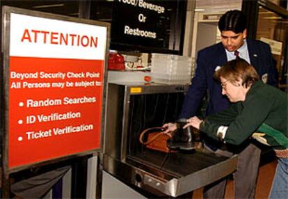 Una pasajera introduce sus zapatos en el escáner del aeropuerto de Boston para que sean inspeccionados.