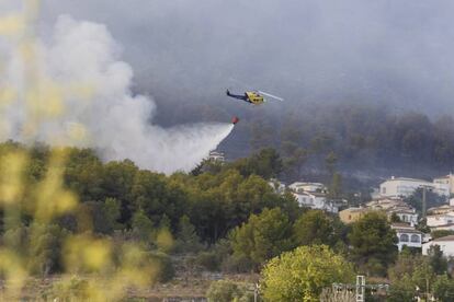 Un helicòpter llança aigua en una urbanització de Xàbia.