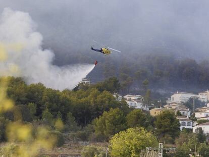 Un helicòpter llança aigua en una urbanització de Xàbia.