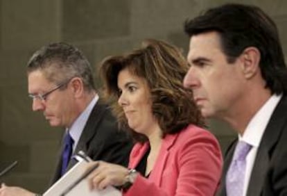 La vicepresidente del Gobierno, Soraya Sáenz de Santamaría, junto a los ministros de Justicia, Alberto Ruiz-Gallardón (i), e Industria, Energía y Turismo, José Manuel Soria, al inicio de la rueda de prensa tras el Consejo de Ministros celebrado en el palacio de La Moncloa.