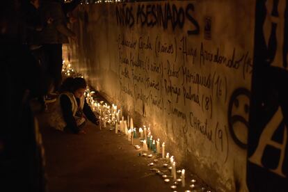 Una niña coloca una vela durante el homenaje en el Estadio Nacional, este lunes