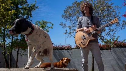 El músico en el jardín de su vivienda en compañía de una de sus guitarras y sus dos perros.


