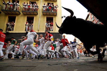 Un toro de la ganadería Domingo Hernández en la curva de Mercaderes, este jueves en el quinto encierro de San Fermín. 