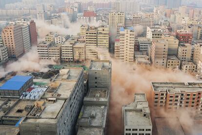 El humo se eleva entre los edificios durante una demolición controlada en la aldea urbana de Zhengzhou, provincia de Henan (China).