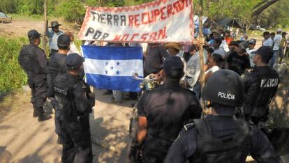 Polic&iacute;as antidisturbios montan guardia mientras un grupo de campesinos abandonan una parcela que hab&iacute;an ocupado al norte de Tegucigalpa.
 